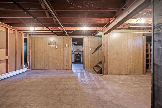 unfinished below grade area featuring stairway, wood walls, washer / clothes dryer, and tile patterned floors