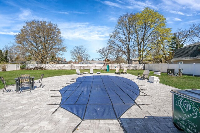 view of swimming pool featuring a yard, a fenced in pool, a patio, and a fenced backyard
