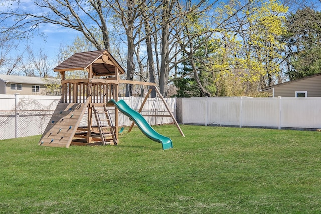 view of playground with a fenced backyard and a lawn