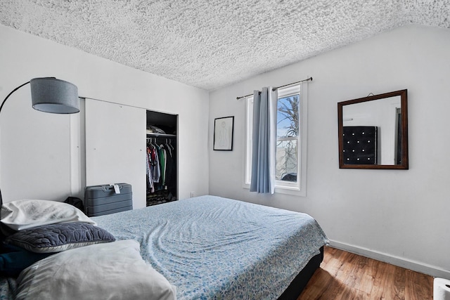 107-50 90th St, Ozone Park, NY 11417 - bedroom featuring a closet, a textured ceiling, baseboards, and wood finished floors