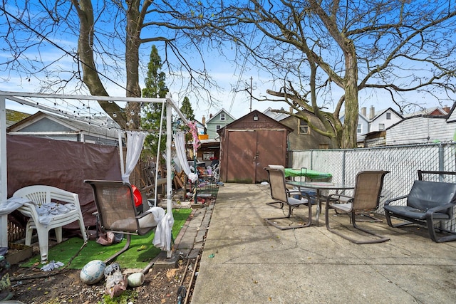 107-50 90th St, Ozone Park, NY 11417 - view of patio featuring a storage shed, outdoor dining space, a fenced backyard, and an outdoor structure