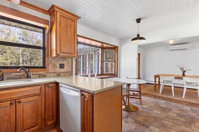 kitchen with a sink, tasteful backsplash, white dishwasher, stone finish flooring, and a wall mounted AC