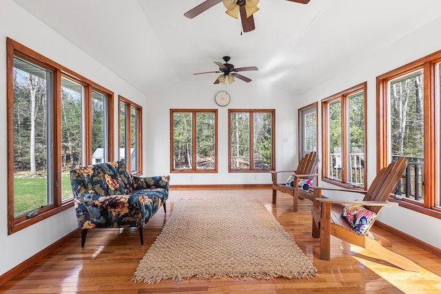 sunroom / solarium featuring wood-type flooring, plenty of natural light, and baseboards
