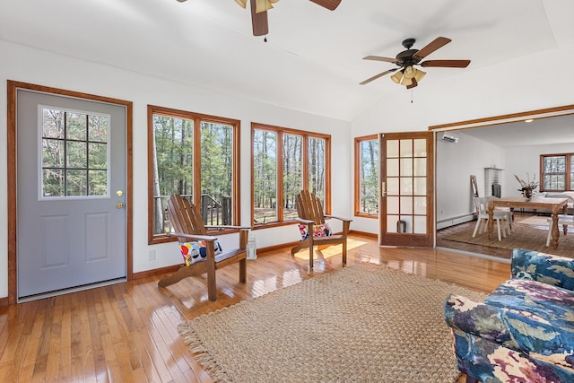 interior space with vaulted ceiling, baseboards, ceiling fan, hardwood / wood-style flooring, and a baseboard radiator