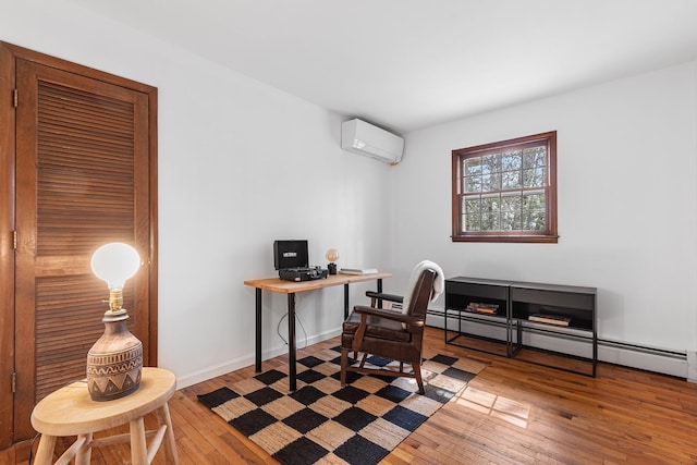 home office featuring a baseboard heating unit, wood-type flooring, baseboards, and a wall unit AC