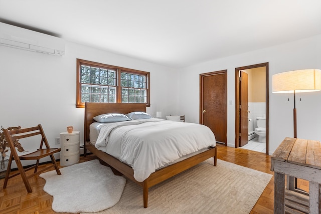 bedroom with ensuite bath, a wall mounted AC, and a baseboard radiator