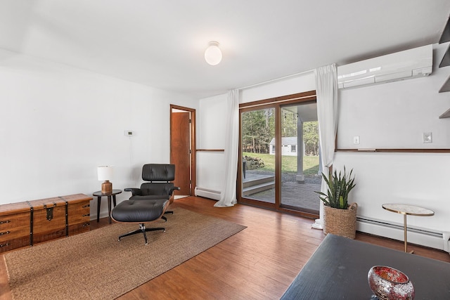sitting room with wood finished floors, a wall mounted AC, and a baseboard radiator