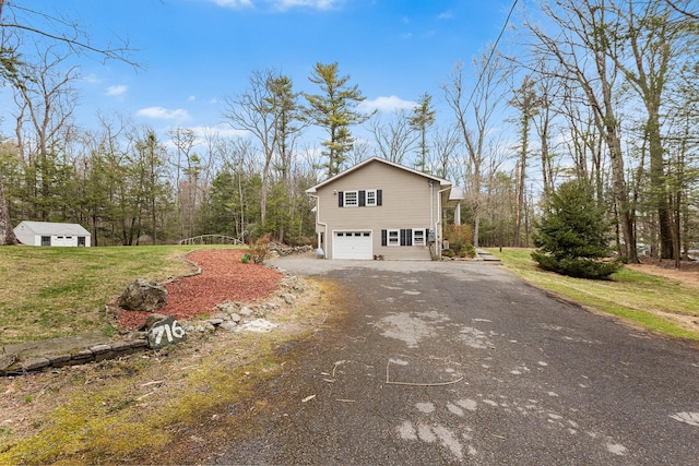 view of home's exterior featuring a lawn, an attached garage, and driveway