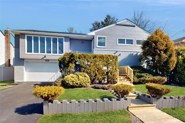 view of front facade featuring a garage, a front yard, driveway, and brick siding