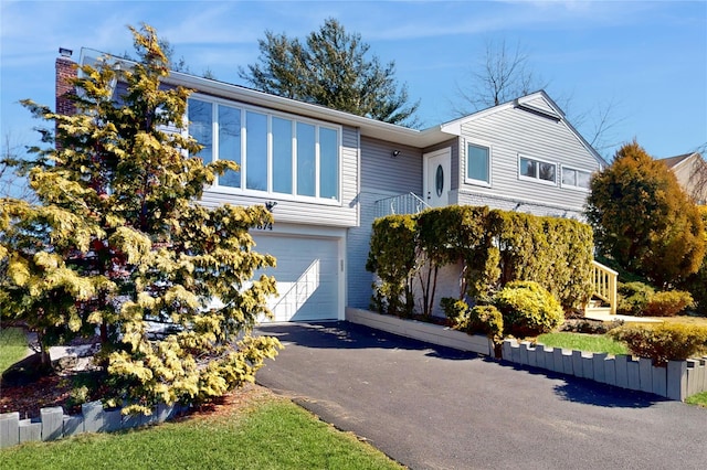 view of front facade featuring a garage and aphalt driveway