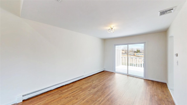 empty room with baseboards, a baseboard heating unit, light wood-type flooring, and visible vents
