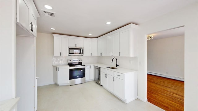 kitchen featuring decorative backsplash, visible vents, a sink, a baseboard radiator, and stainless steel appliances