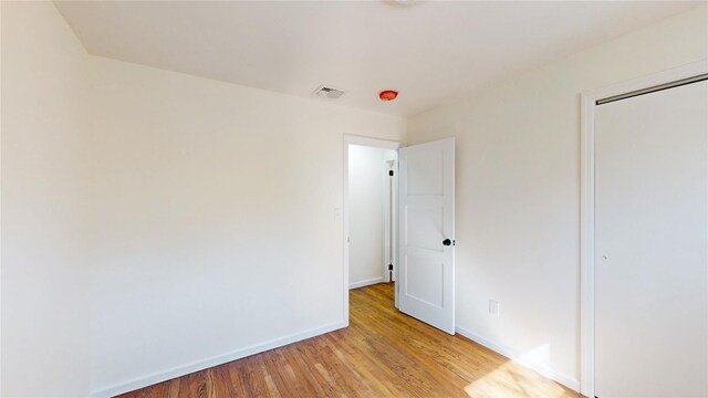 unfurnished room with light wood-style floors, baseboards, and visible vents