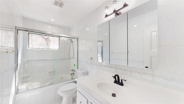 full bathroom with vanity, enclosed tub / shower combo, toilet, and visible vents