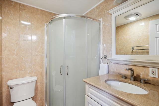 bathroom with vanity, toilet, tile walls, and a stall shower
