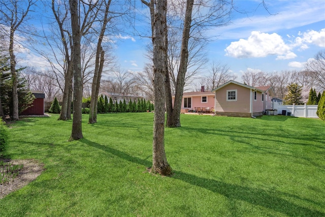 view of yard with fence and an outdoor structure