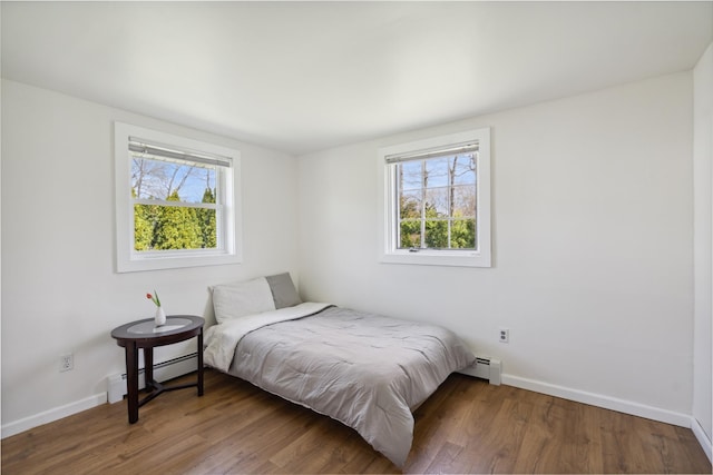 bedroom with baseboards, multiple windows, and a baseboard radiator