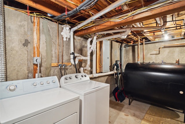 clothes washing area with washer and dryer, laundry area, and heating fuel