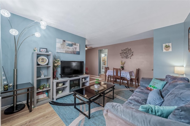 living area with wood finished floors and a ceiling fan