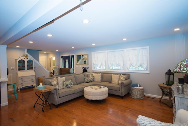 living area featuring baseboards, wood finished floors, recessed lighting, and stairway