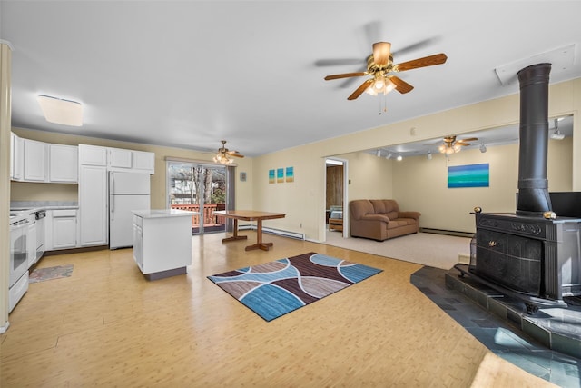 44 Nottingham Gate Rd, Rock Hill, NY 12775 - living area with a wood stove, a ceiling fan, a baseboard heating unit, and light wood finished floors