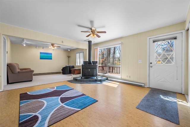 44 Nottingham Gate Rd, Rock Hill, NY 12775 - interior space featuring a baseboard radiator, wood finished floors, ceiling fan, and a wood stove
