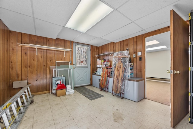 44 Nottingham Gate Rd, Rock Hill, NY 12775 - below grade area with wooden walls, a baseboard radiator, tile patterned floors, and a drop ceiling