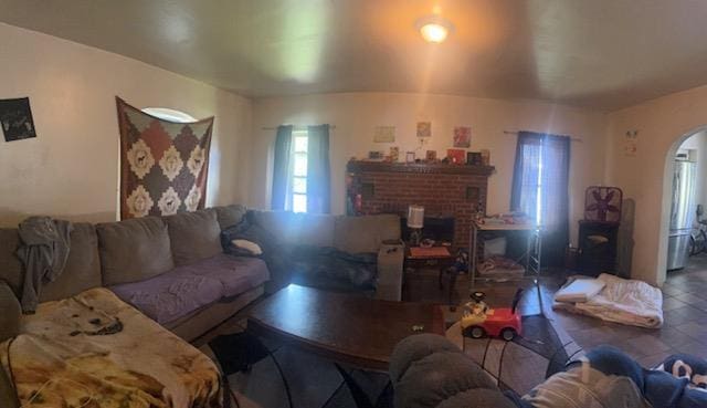 living room with arched walkways and a fireplace