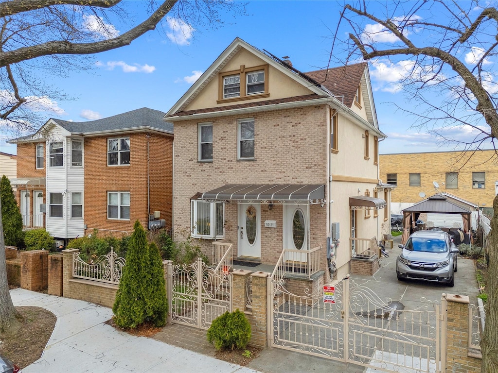 59-21 Fresh Meadow Ln, Fresh Meadows, NY 11365 - view of front of house featuring a fenced front yard, stucco siding, a gate, brick siding, and concrete driveway