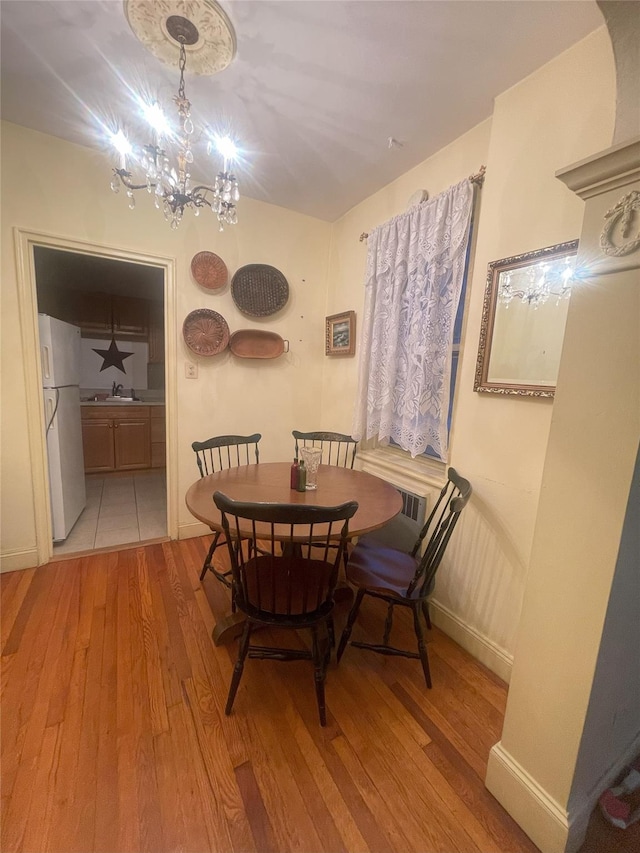 63-61 99th St Unit A4, Rego Park, NY 11374 - dining room with light wood-style floors, an inviting chandelier, and baseboards