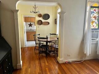 63-61 99th St Unit A4, Rego Park, NY 11374 - dining area with ornate columns, arched walkways, wood finished floors, a chandelier, and baseboards