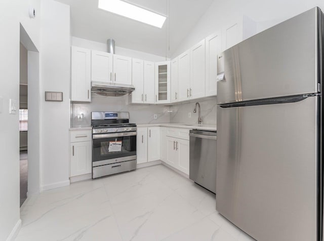kitchen with light countertops, under cabinet range hood, white cabinetry, stainless steel appliances, and backsplash