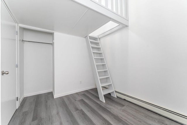 spacious closet featuring baseboard heating and wood finished floors