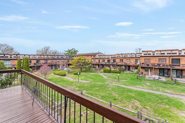 wooden terrace with a residential view and a lawn
