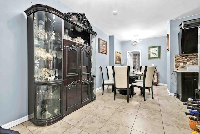 dining room with light tile patterned floors, baseboards, and a notable chandelier