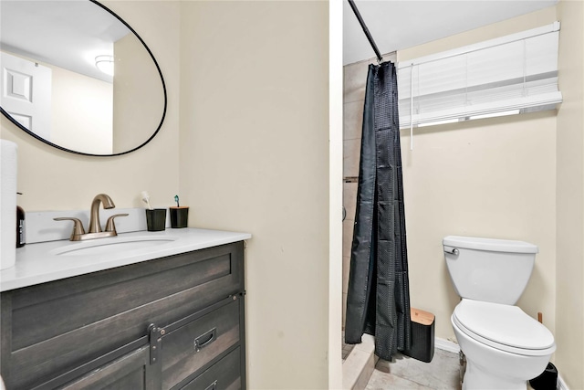 bathroom with toilet, curtained shower, vanity, and baseboards