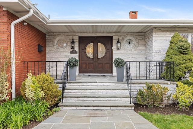 187 Jackson Ave, Pelham, NY 10803 - property entrance with stone siding, a chimney, and covered porch
