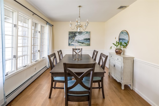 dining area featuring an inviting chandelier, visible vents, light wood-type flooring, and baseboard heating