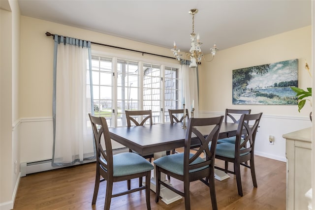 dining area featuring a notable chandelier, wood finished floors, and baseboards