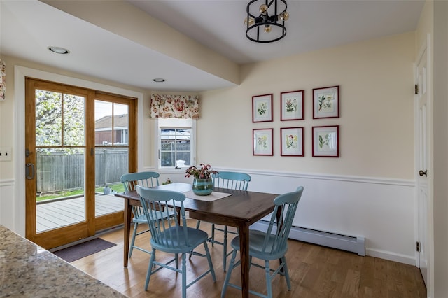 dining area featuring baseboard heating, baseboards, recessed lighting, wood finished floors, and a notable chandelier