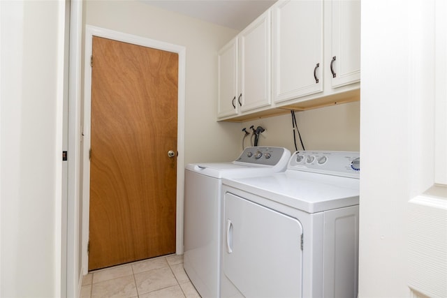 laundry area featuring light tile patterned flooring, washing machine and clothes dryer, and cabinet space