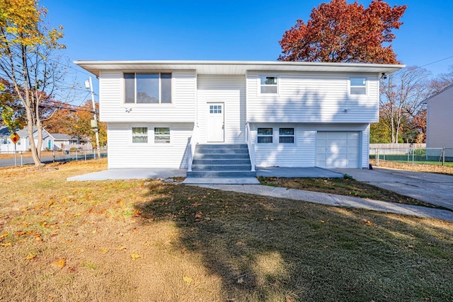 view of front of home featuring driveway, fence, a garage, and a front lawn