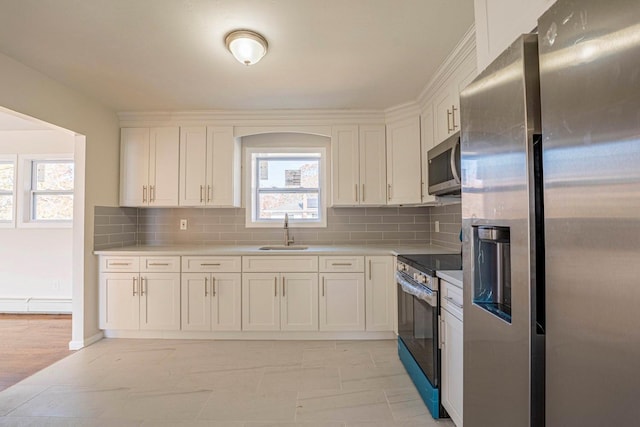 kitchen featuring white cabinets, light countertops, a sink, and appliances with stainless steel finishes