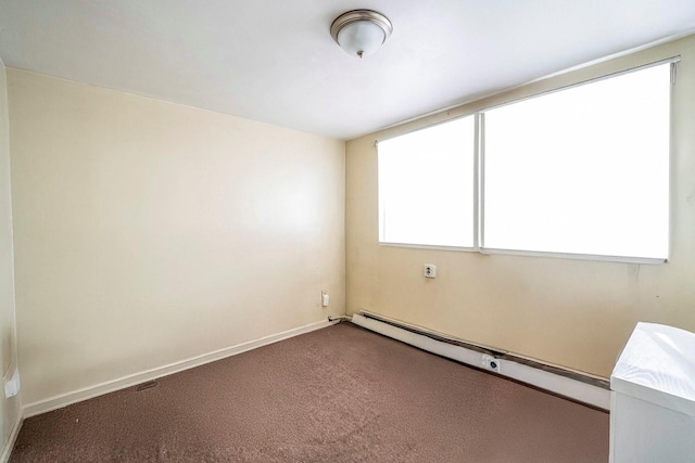 spare room featuring baseboards, dark colored carpet, and baseboard heating