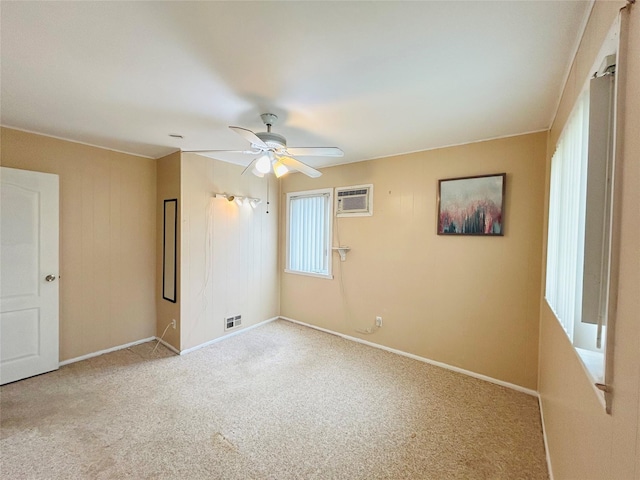 carpeted empty room featuring visible vents, baseboards, a ceiling fan, and an AC wall unit