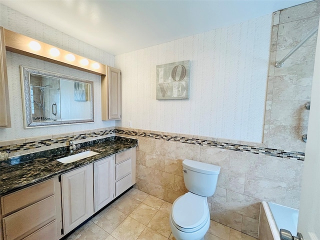 full bathroom with tile walls, toilet, vanity, tiled shower, and tile patterned flooring