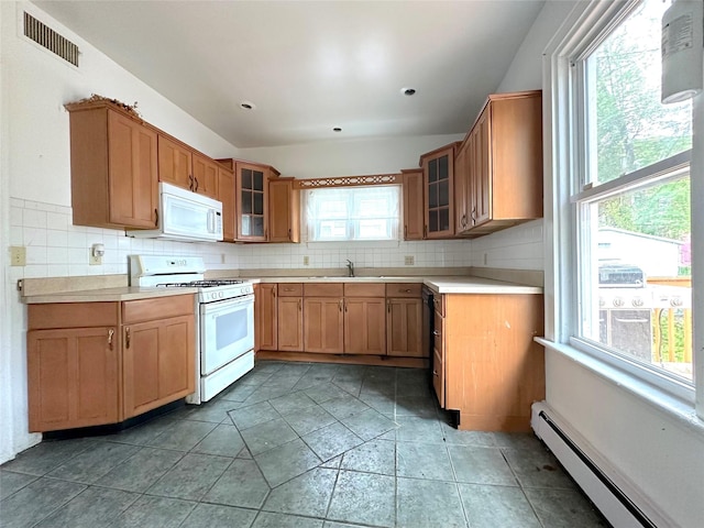 kitchen with visible vents, a healthy amount of sunlight, white appliances, and baseboard heating