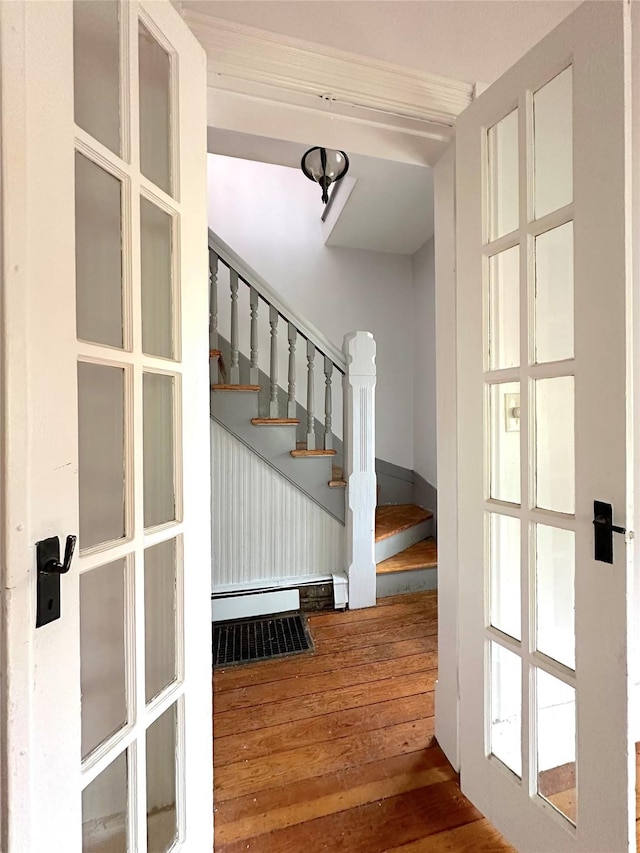 stairs featuring a baseboard radiator and wood-type flooring