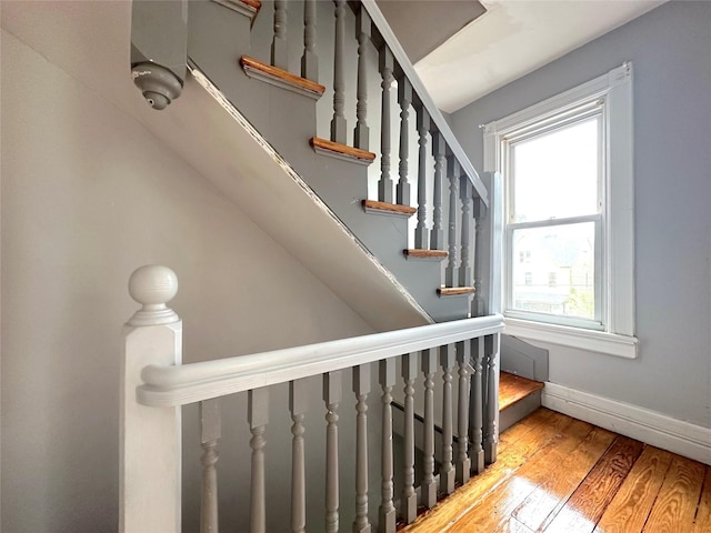 stairway with wood finished floors and baseboards