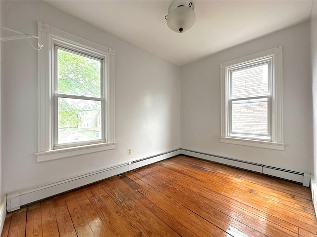 spare room featuring hardwood / wood-style floors and a baseboard heating unit
